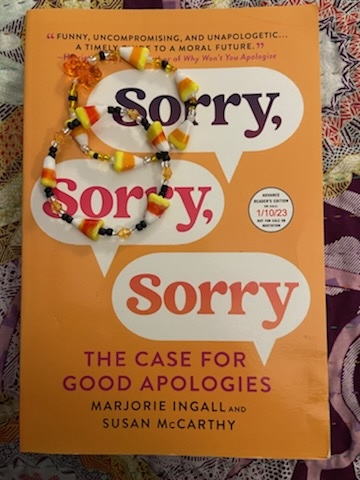 image of an Advance Reader Copy of Sorry, Sorry, Sorry: The Case for Good Apologies (Snarly and Sumac's forthcoming book) with two candy corn bracelets resting on it. 