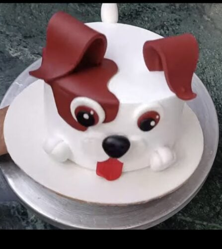 Cake decorated to look like a cartoon dog, with spots and floppy ears.